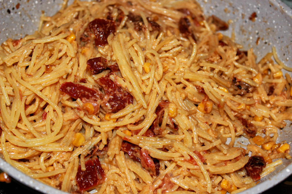 Glutenfreie Spaghetti mit getrockneten Tomaten in Pfanne